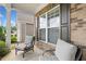 Comfortable front porch with seating, showcasing brickwork, large windows, and a glimpse of the neighborhood at 215 Windsor Park Dr, Woodstock, GA 30188
