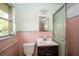 Classic bathroom with pink tile, sink, and shower with a glass door at 3179 Dogwood Dr, Atlanta, GA 30344