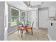 Cozy breakfast nook features a glass table, four chairs, and plenty of natural light from the large windows at 3358 North Ct, Ellenwood, GA 30294