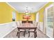 Inviting dining room features warm yellow walls, a large wooden table, and modern chandelier at 3358 North Ct, Ellenwood, GA 30294