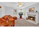 Cozy living room featuring an orange sofa, fireplace, ceiling fan, and natural light at 3358 North Ct, Ellenwood, GA 30294
