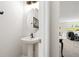 Well-lit powder room featuring a pedestal sink, a modern mirror, and a clean, minimalist design at 554 Rendevous Rd, Acworth, GA 30102