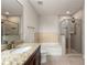 Stylish bathroom featuring granite counters, vanity mirror, soaking tub, and glass-enclosed shower at 855 Peachtree Ne St # 3205, Atlanta, GA 30308