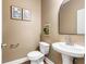 Stylish powder room featuring a modern pedestal sink, decorative mirror, and tasteful wall art at 1839 Tranquil Field Nw Dr, Acworth, GA 30102