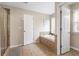 Bright bathroom features a tiled floor, a soaking tub, and a separate tiled shower stall at 1839 Tranquil Field Nw Dr, Acworth, GA 30102