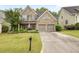 Charming two-story brick home featuring a well-manicured lawn, mature trees, and a two-car garage at 1839 Tranquil Field Nw Dr, Acworth, GA 30102