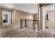 Upstairs hallway with carpet, wrought iron railing and view of doorway with bedroom beyond at 1839 Tranquil Field Nw Dr, Acworth, GA 30102