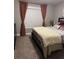 Cozy bedroom with warm carpeting, a decorative bedspread, and natural light from the window at 2709 Ratby Ne Ln, Conyers, GA 30013