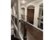 Upper hallway with elegant arched doorways, dark wood floors, and stylish railing overlooking the lower level at 2709 Ratby Ne Ln, Conyers, GA 30013