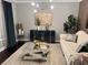 Luxurious living room with stylish decor, a mirrored coffee table, and elegant furnishings creating an inviting space at 2709 Ratby Ne Ln, Conyers, GA 30013