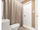 This bathroom features a toilet, shower with curtain, white door and tan colored walls at 3310 Vista Creek Dr, Dacula, GA 30019