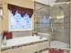 Bathroom with a jetted tub, glass shower and a large window with a decorative flower mural at 3310 Vista Creek Dr, Dacula, GA 30019