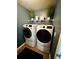 Laundry room with a blue wall and modern washer and dryer at 5848 Rex Ridge Loop, Rex, GA 30273
