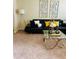Stylish living room featuring a comfortable black sectional, modern glass coffee table, and chic decor at 5848 Rex Ridge Loop, Rex, GA 30273