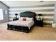 Spacious main bedroom featuring a tufted headboard and striped accent wall, creating an elegant and inviting retreat at 5848 Rex Ridge Loop, Rex, GA 30273