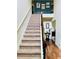 Carpeted staircase with wood railing and iron spindles leading to the upper level of the home at 5848 Rex Ridge Loop, Rex, GA 30273