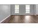 Cozy bedroom features wood-look floors, two windows for natural light, and neutral gray walls at 2505 Se Tiffany Ct, Conyers, GA 30013