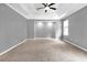 Spacious main bedroom features a tray ceiling, ceiling fan, neutral paint, and plush carpet at 2505 Se Tiffany Ct, Conyers, GA 30013