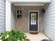 Inviting front entry featuring a brick facade, covered porch, and a black front door at 2508 Norwood Park Xing, Atlanta, GA 30340