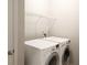 Bright laundry room features a modern washer and dryer with a white storage rack at 2508 Norwood Park Xing, Atlanta, GA 30340
