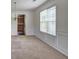 Inviting dining space with classic wainscoting, a window, and carpet, open to the kitchen for easy entertaining at 347 Cobblestone Court, Hampton, GA 30228