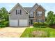 Charming two-story home featuring stone accents, a two-car garage, and a well-manicured front yard at 347 Cobblestone Court, Hampton, GA 30228