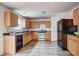 Functional kitchen with wood cabinets, black appliances, laminate counters, and wood-look flooring at 347 Cobblestone Court, Hampton, GA 30228