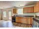 Bright eat-in kitchen features wood cabinets, a double sink, and appliances with wood-look vinyl flooring at 347 Cobblestone Court, Hampton, GA 30228