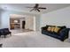 Inviting living room featuring a ceiling fan, plush seating, and seamless access to the kitchen and stairway at 347 Cobblestone Court, Hampton, GA 30228
