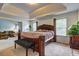 Comfortable main bedroom featuring a large bed, natural light, and a seating bench at 347 Cobblestone Court, Hampton, GA 30228