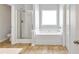 Bright bathroom featuring a tub, shower, and tile flooring at 911 Sonoma Dr, Lawrenceville, GA 30045