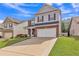View of a two-story home featuring a well-kept lawn, an attached garage, and manicured landscaping at 911 Sonoma Dr, Lawrenceville, GA 30045