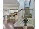 Open staircase with iron railing, hardwood floors, and a view into the modern kitchen at 911 Sonoma Dr, Lawrenceville, GA 30045