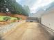Spacious backyard with a concrete patio, wood fencing, and lush greenery, perfect for outdoor entertaining at 3484 Lynley Mill Ln, Dacula, GA 30019