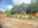 The backyard has lush greenery, a wooden fence, and a retaining wall at 3484 Lynley Mill Ln, Dacula, GA 30019