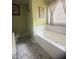 Bright bathroom showcasing a large soaking tub, neutral tile flooring and olive-painted walls, creating a serene space at 3484 Lynley Mill Ln, Dacula, GA 30019