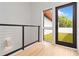 View from Balcony: Modern balcony with wood floors, glass railing, and a view of a large green yard at 367 Parkway Ne Dr # 3, Atlanta, GA 30312