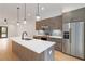 A modern kitchen features an island with seating, stainless appliances, gray cabinets, and recessed lighting at 367 Parkway Ne Dr # 3, Atlanta, GA 30312