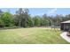 Expansive backyard with a lush lawn, wooden fence, mature trees, and play equipment at 1660 Chandler Rd, Lawrenceville, GA 30045