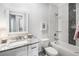Well-lit bathroom with tiled shower and tub, granite counters, modern fixtures, and a decorative mirror at 1660 Chandler Rd, Lawrenceville, GA 30045