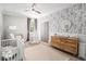 Charming Bedroom featuring floral wallpaper, modern ceiling fan and a crib with decor at 1660 Chandler Rd, Lawrenceville, GA 30045