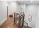 Hallway with hardwood floors and decorative railing leading to an upper level at 1660 Chandler Rd, Lawrenceville, GA 30045