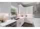 Charming kitchen with white cabinets, stainless steel appliances, quartz countertops and a view from the window at 1660 Chandler Rd, Lawrenceville, GA 30045