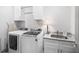 Modern laundry room with washer, dryer, cabinets, sink and granite countertop at 1660 Chandler Rd, Lawrenceville, GA 30045