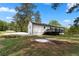 Large backyard with grass and trees, featuring a black deck and plenty of room for activities at 2014 Fence Rd, Dacula, GA 30019