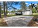 Basketball court with house and large backyard area surrounded by mature trees and blue skies at 2014 Fence Rd, Dacula, GA 30019