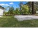 Large cement basketball court sits in a backyard with mature trees and a house in the background at 2014 Fence Rd, Dacula, GA 30019