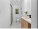 Modern bathroom featuring a glass enclosed shower, white marble flooring, and modern wood vanity at 2014 Fence Rd, Dacula, GA 30019
