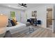 Bright and modern bedroom with a ceiling fan, light wood floors, and a white comforter at 2014 Fence Rd, Dacula, GA 30019