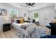Bright and modern bedroom with a ceiling fan, light wood floors, and a white comforter at 2014 Fence Rd, Dacula, GA 30019